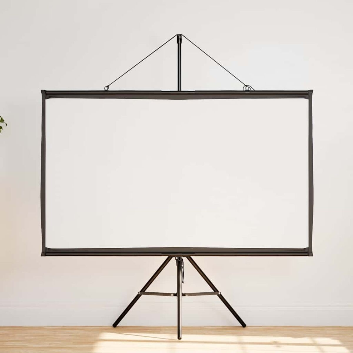 Weiße Projektionsleinwand auf einem schwarzen Stativ. Weiße Wand und Holzfußboden.