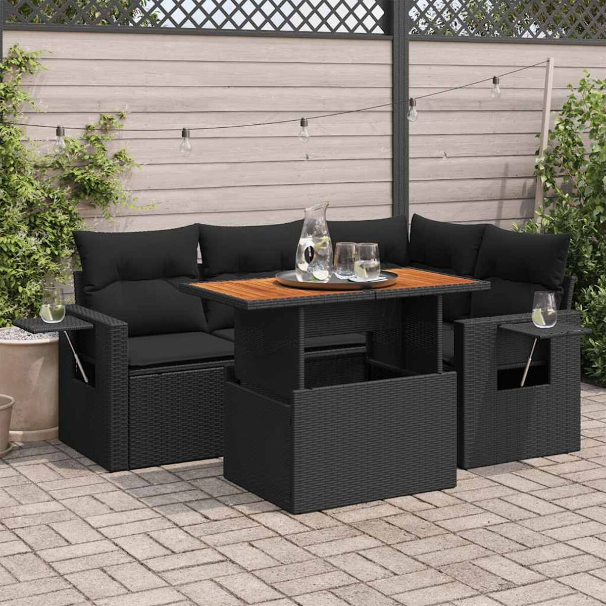 Schwarzes Outdoor-Sofa-Set mit Holztisch, Gläsern und Krug.