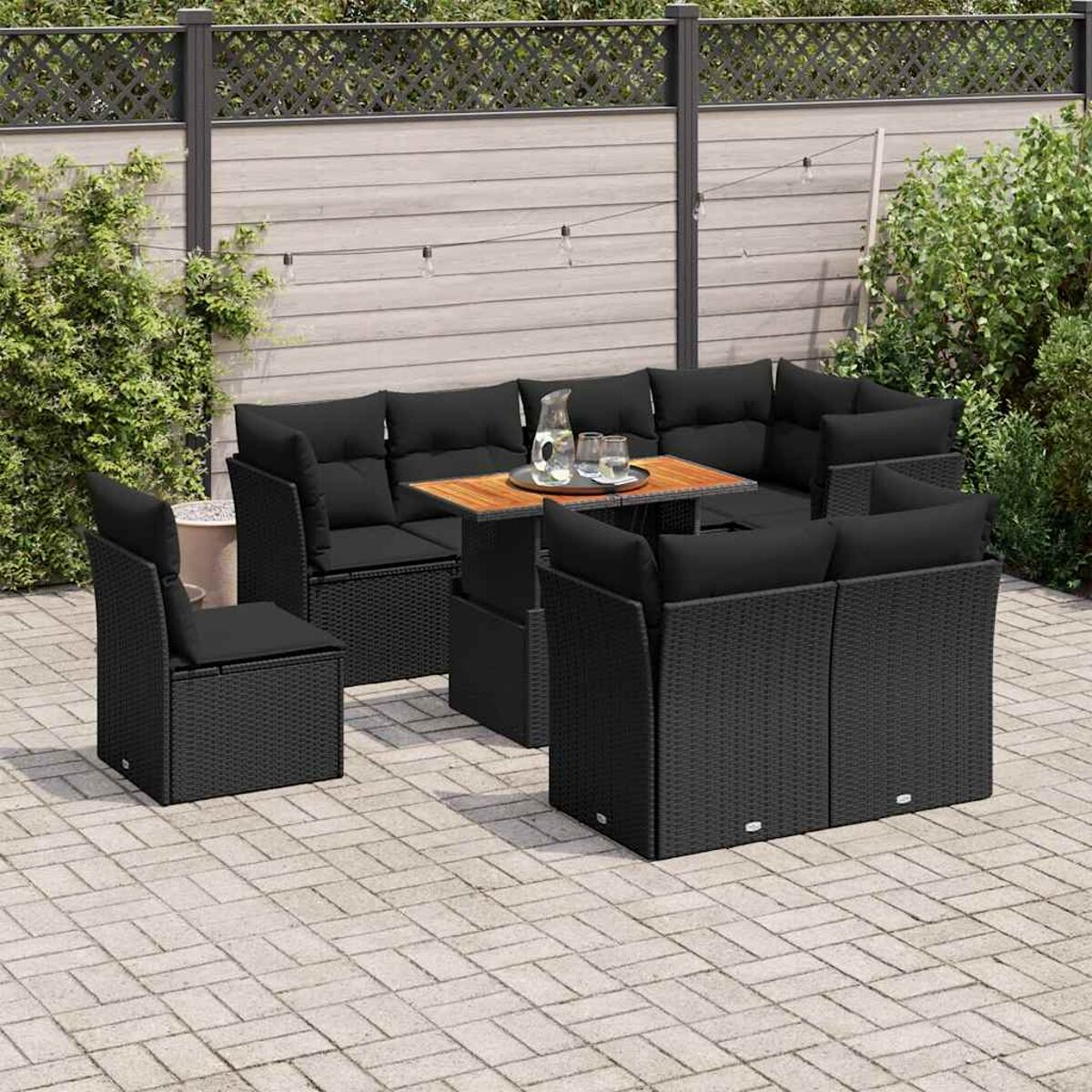 Set di mobili da patio neri con tavolo e sedie. Il set si trova su piastrelle di pietra.