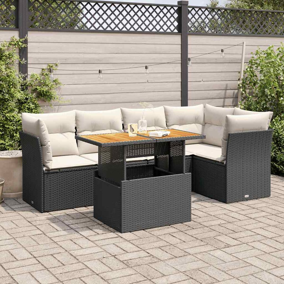 Set divano da esterno con tavolo. Vimini grigio scuro e cuscini color crema.