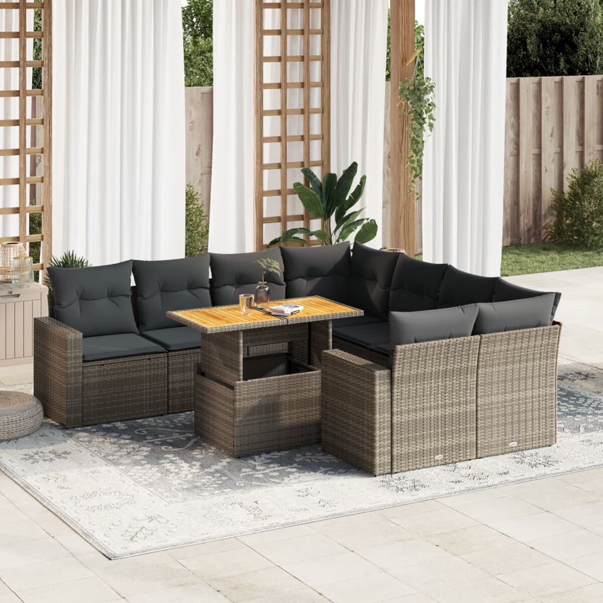 Sitzbereich im Freien mit einem geflochtenen Ecksofa, einem Holztisch und einem gemusterten Teppich.