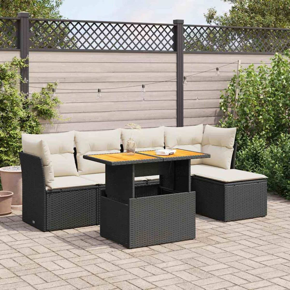 Juego de muebles de patio negro con cojines y mesa.