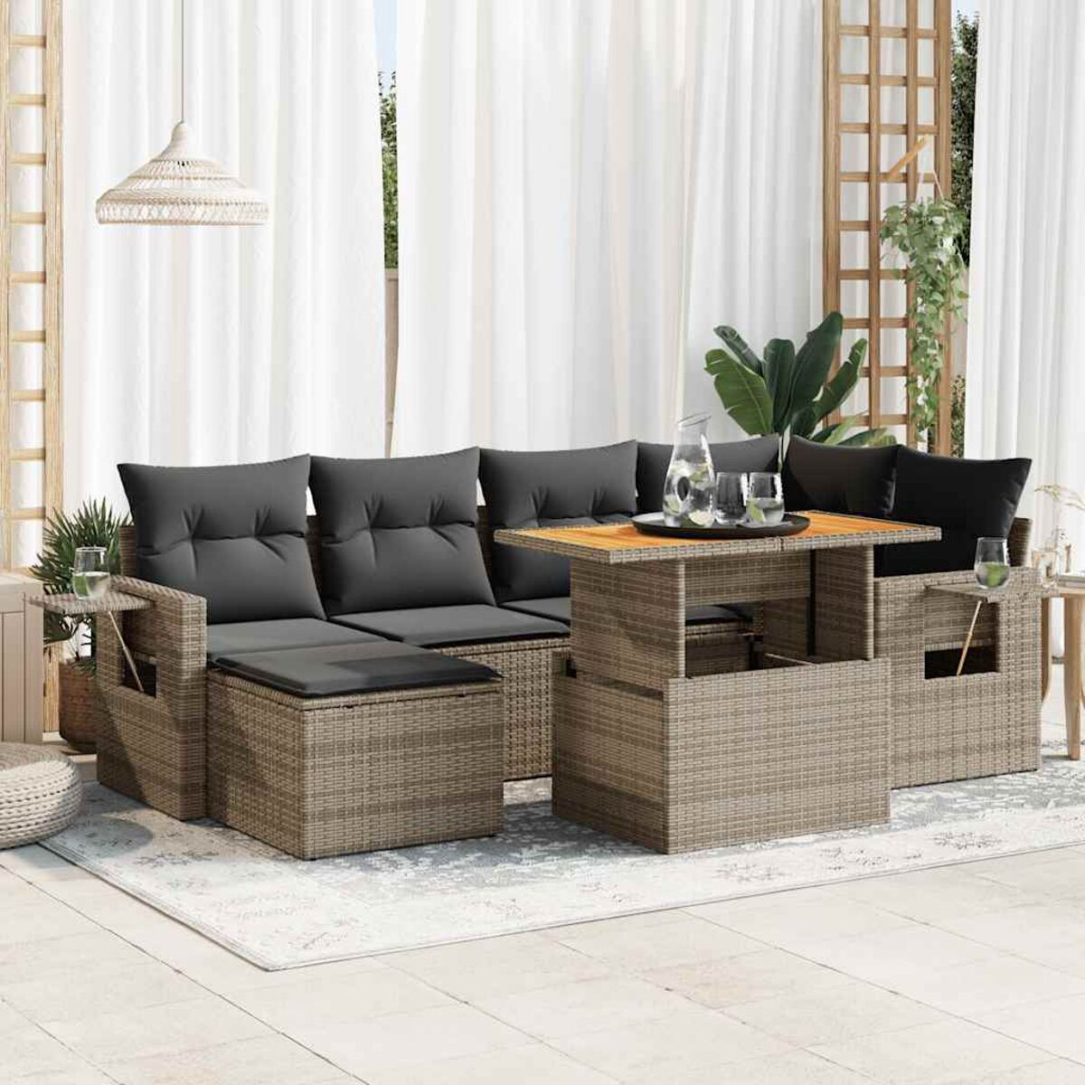 Outdoor-Rattansofa mit grauen Kissen und Couchtisch. Sonniger Hintergrund.