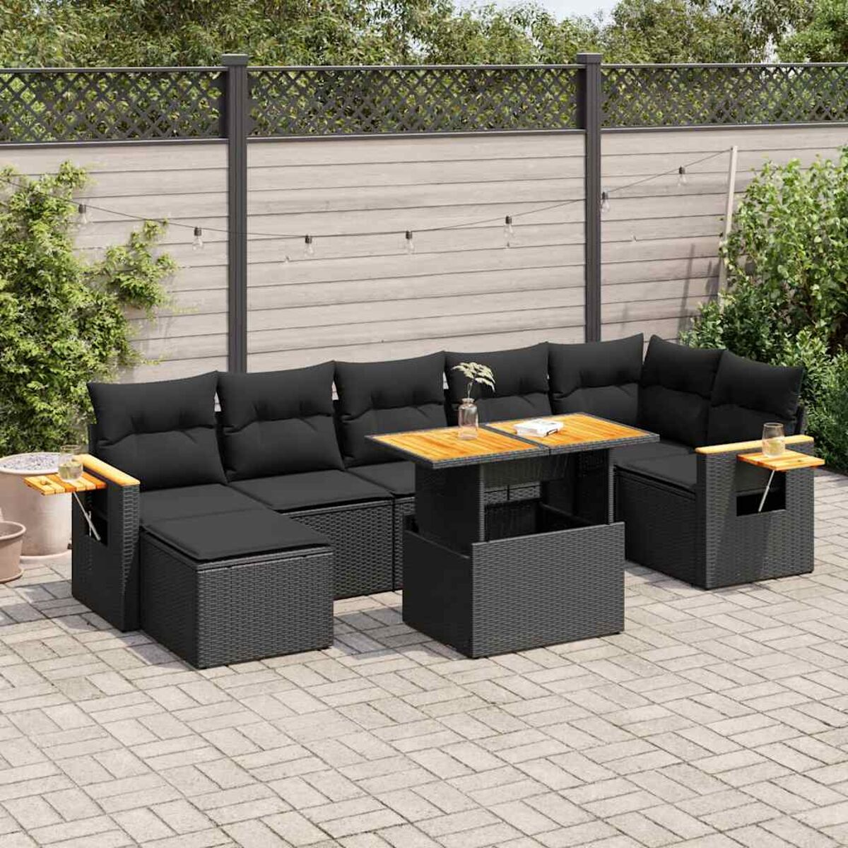 Ein schwarzes Rattan-Ecksofa-Set für den Außenbereich. Ein Tisch steht in der Mitte. Die Umgebung ist eine Terrasse.