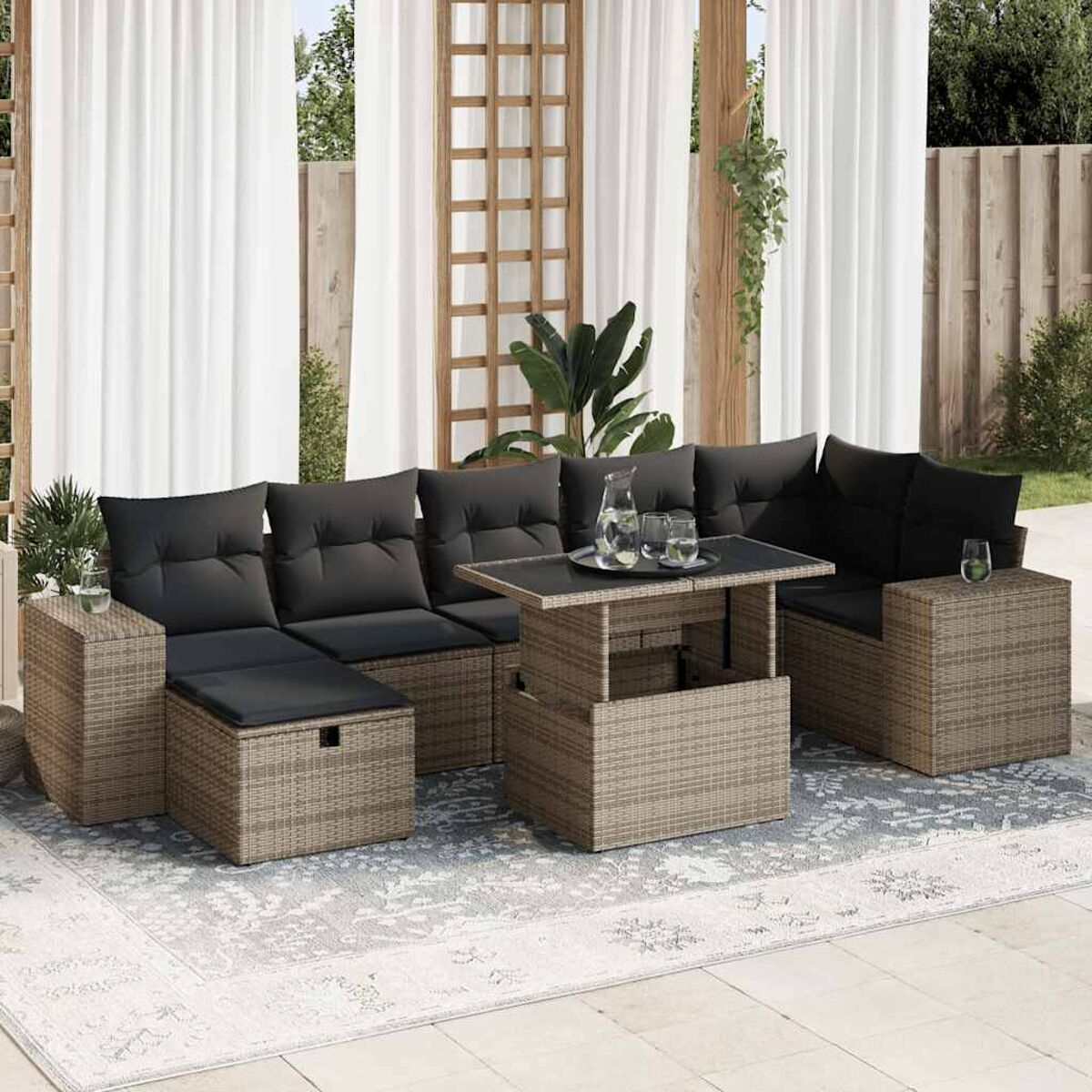 Set divano esterno in vimini nero con cuscini neri, tavolo elevabile e bicchieri. Tappeto grigio.