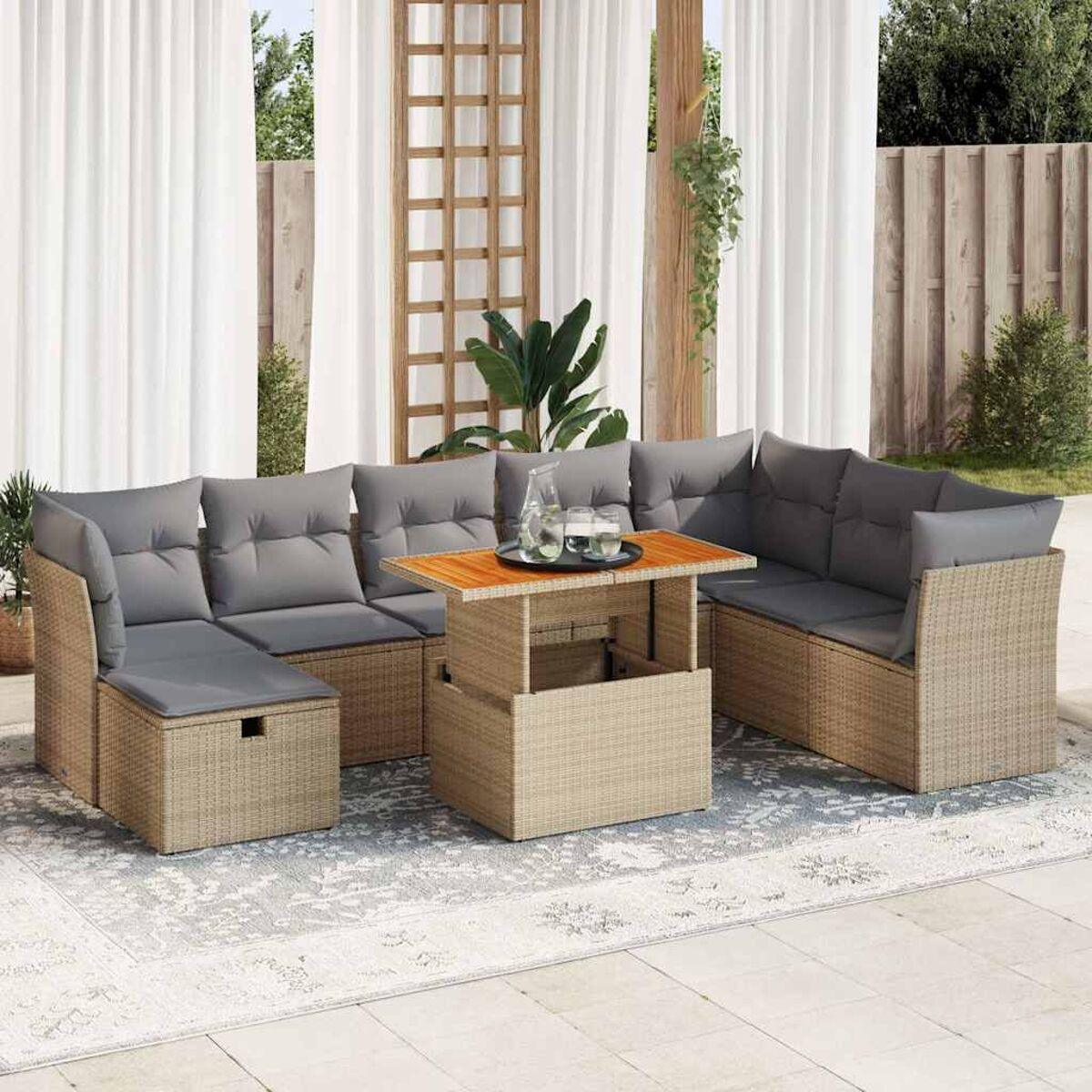 Geflochtenes Terrassenset mit Hubtisch. Graue Kissen, Teppich und Vorhänge sichtbar.