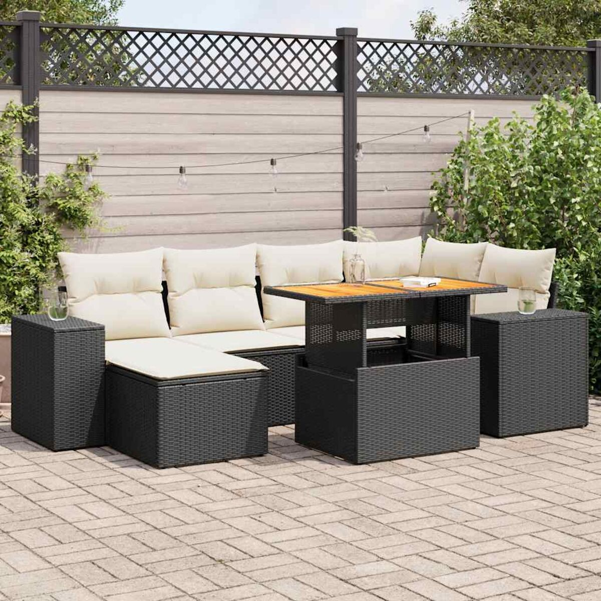 Un set da patio esterno grigio scuro con cuscini beige, un tavolo di legno e un patio in mattoni.