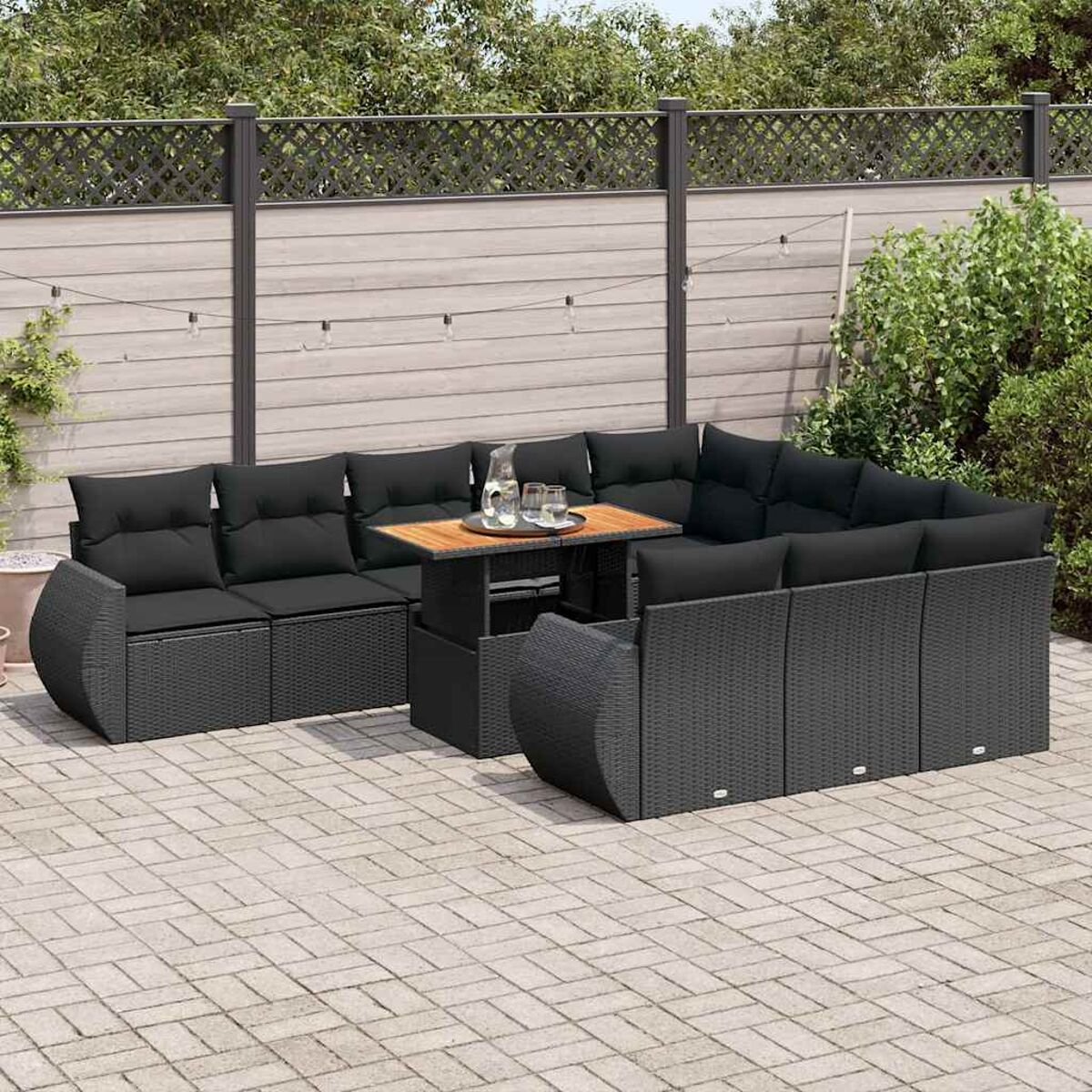 Schwarzes Gartenmöbel-Set auf einer Terrasse mit Holztisch.