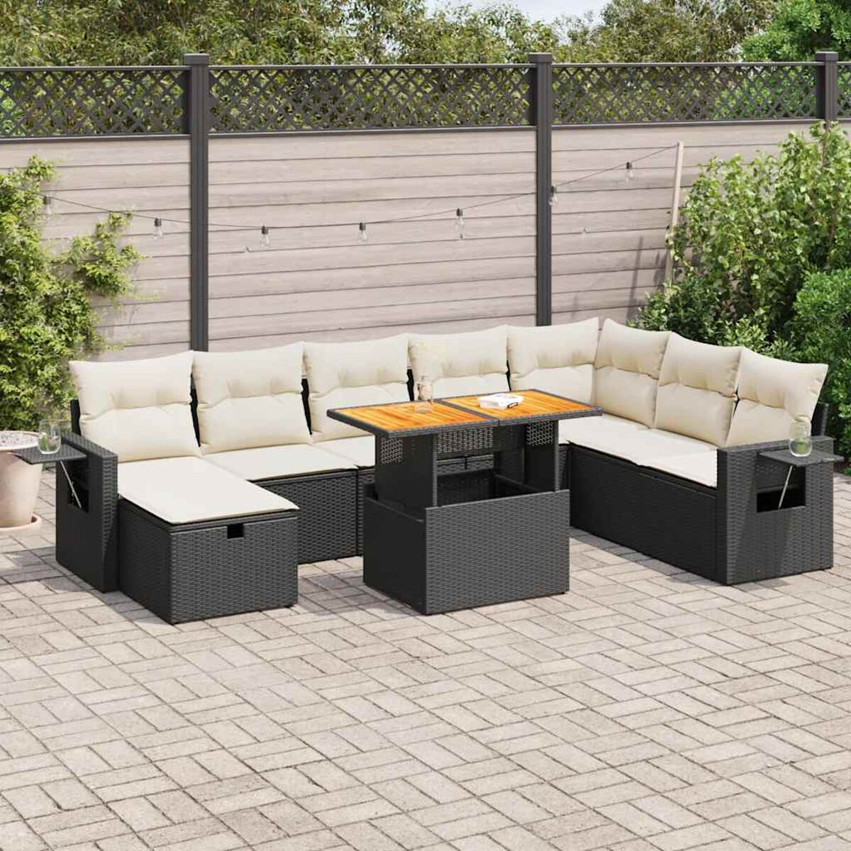 Ein schwarzes Outdoor-Sofa-Set mit einem Tisch. Das Set befindet sich auf einer Ziegelterrasse mit einem Zaun.