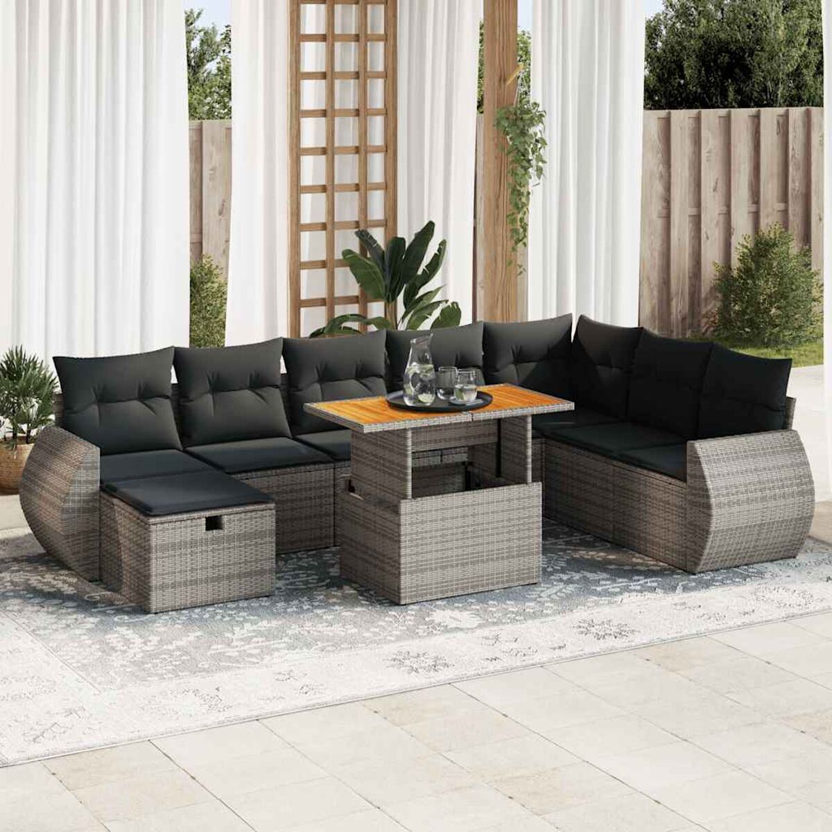 Outdoor-Rattan-Sektion mit grauen Kissen, Holztisch und Teppich.