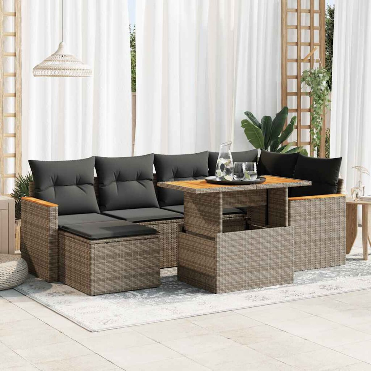 Set divano in rattan da esterno con tavolino e cuscini.