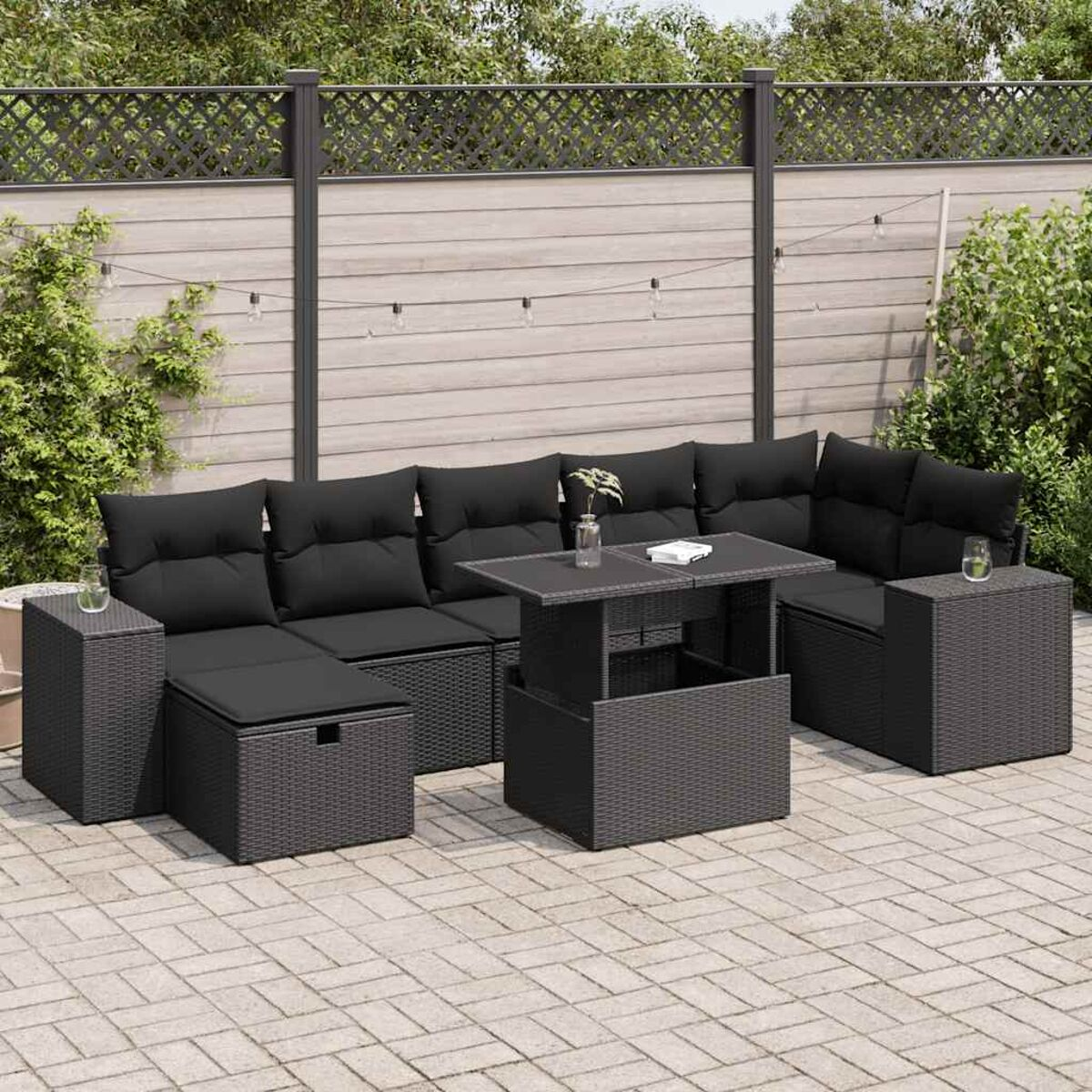 Set di mobili da esterno neri con tavolo elevabile, su patio.