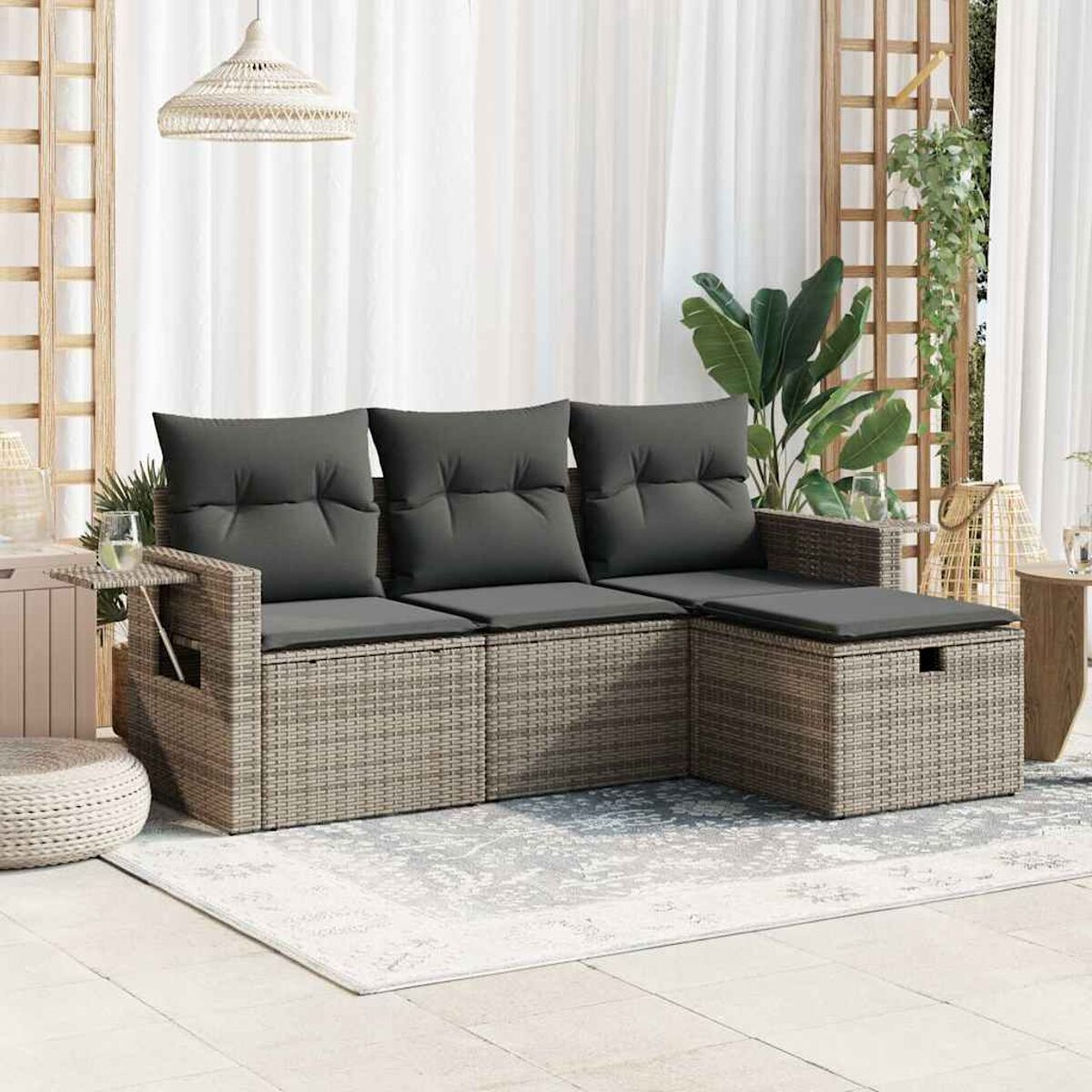 L-förmiges Outdoor-Sofa mit Kissen. Ein Beistelltisch und ein Teppich sind vorhanden.