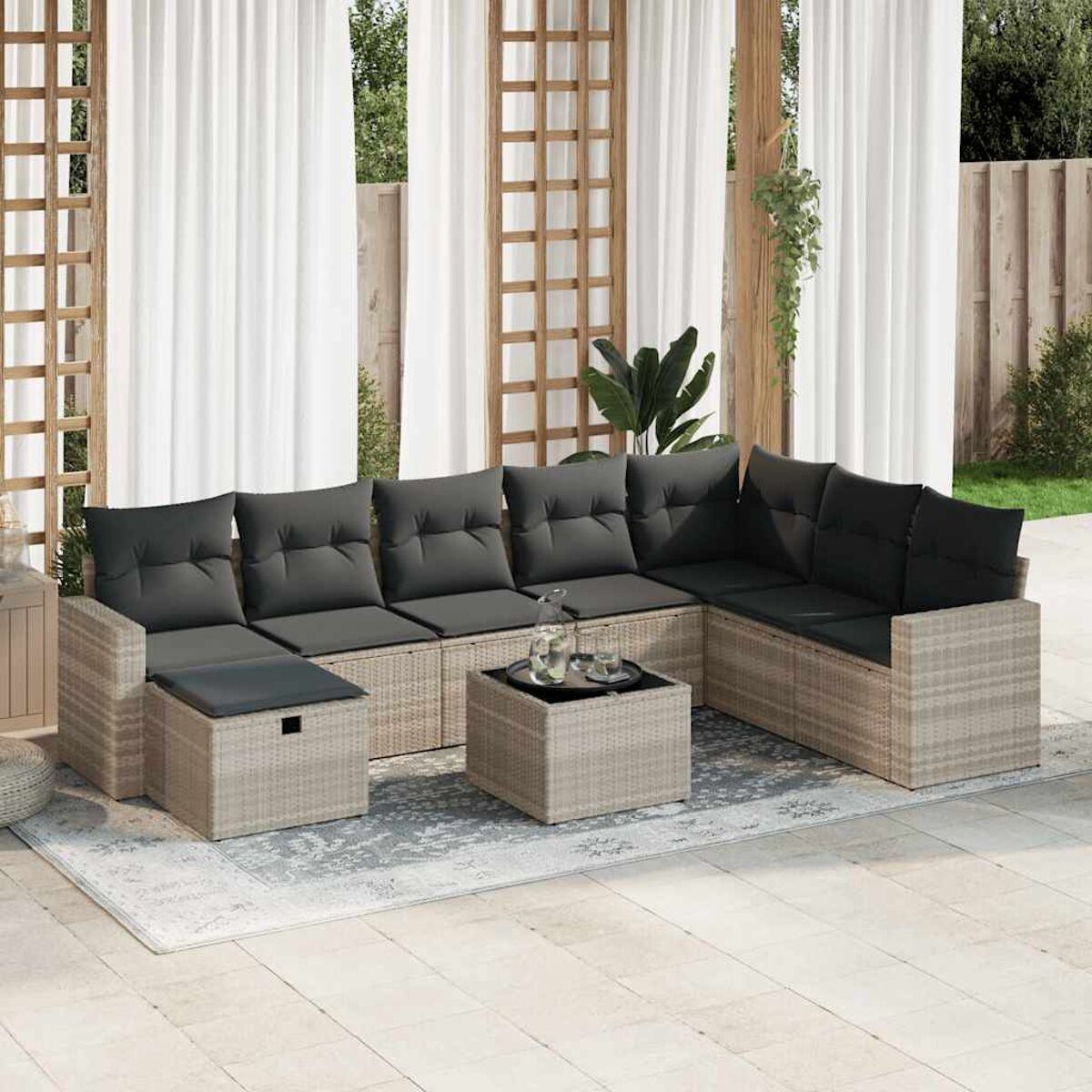 Outdoor-Sofagarnitur mit grauen Kissen und kleinem Tisch. Beiger, gewebter Rahmen. Weißer Vorhanghintergrund.