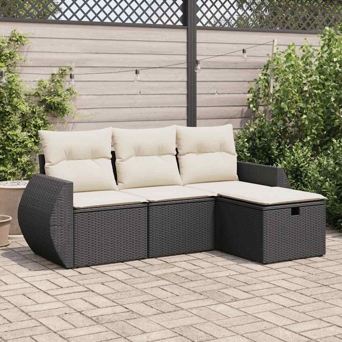 Outdoor-Sofagarnitur. Dunkelgraues Rattan, beige Kissen. Auf Ziegelterrasse. Sonniger Tag.