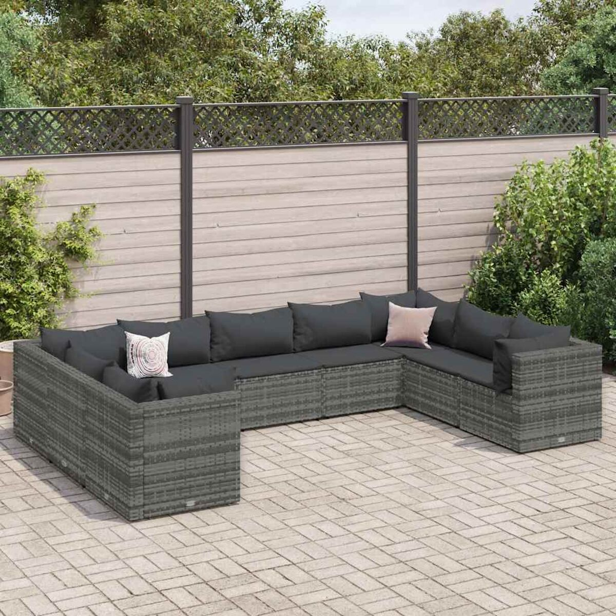 Sofá en U de ratán gris con cojines, exterior, patio de ladrillos.