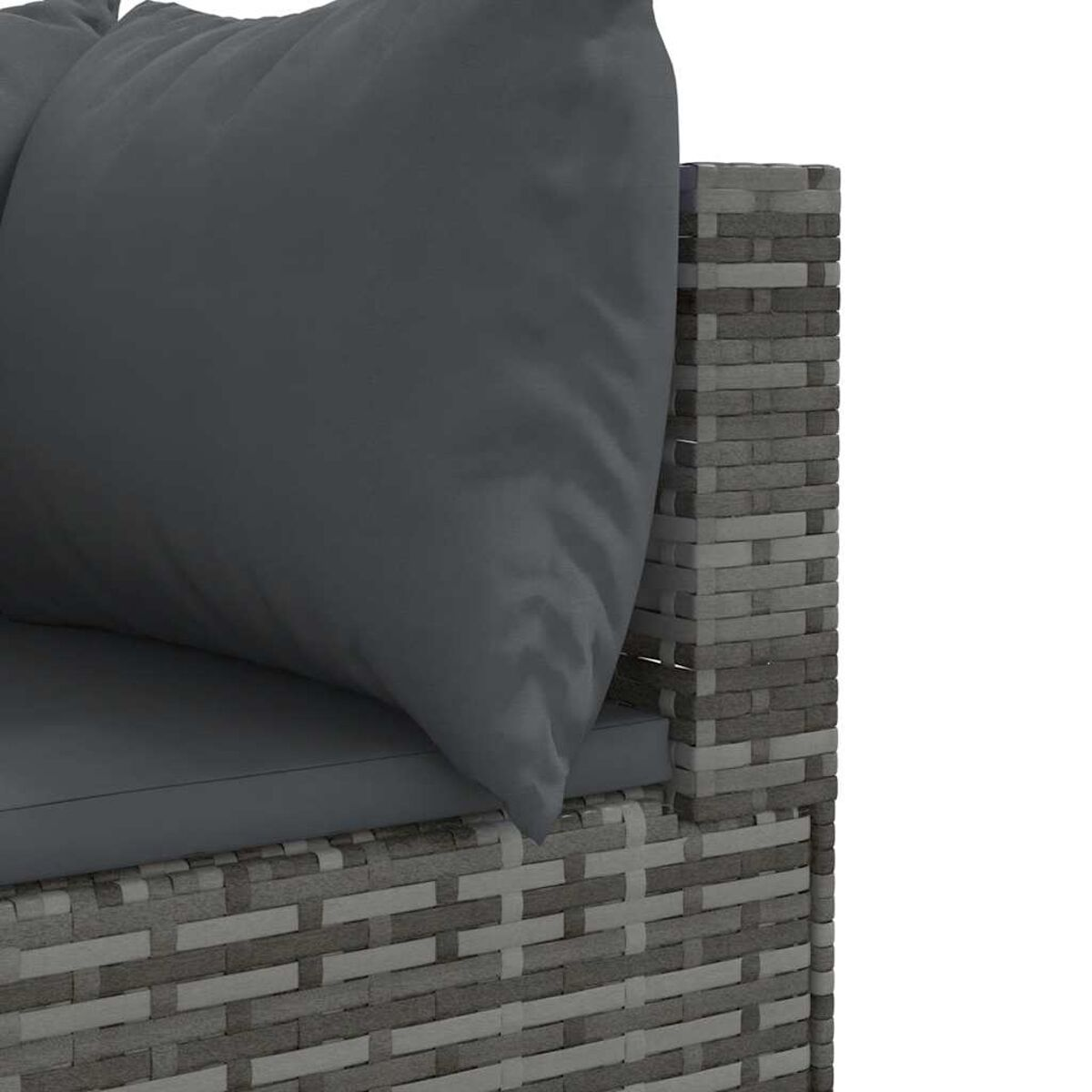 Primer plano de cojín de sofá gris oscuro sobre muebles de mimbre.