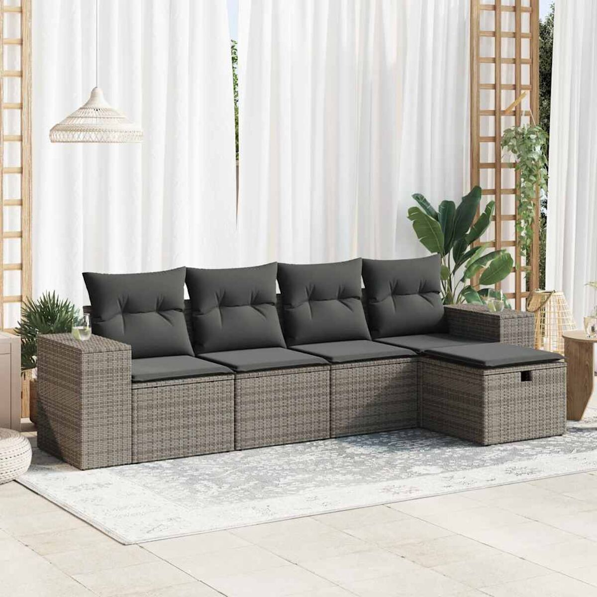 Ein graues Ecksofa aus Korbgeflecht mit grauen Kissen im Freien.