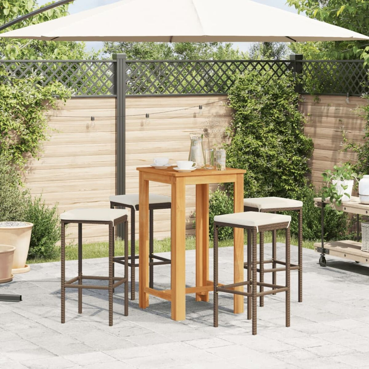 Outdoor-Barbereich mit Holztisch, Hockern und Sonnenschirm. Der Hintergrund ist ein Zaun und Grün.