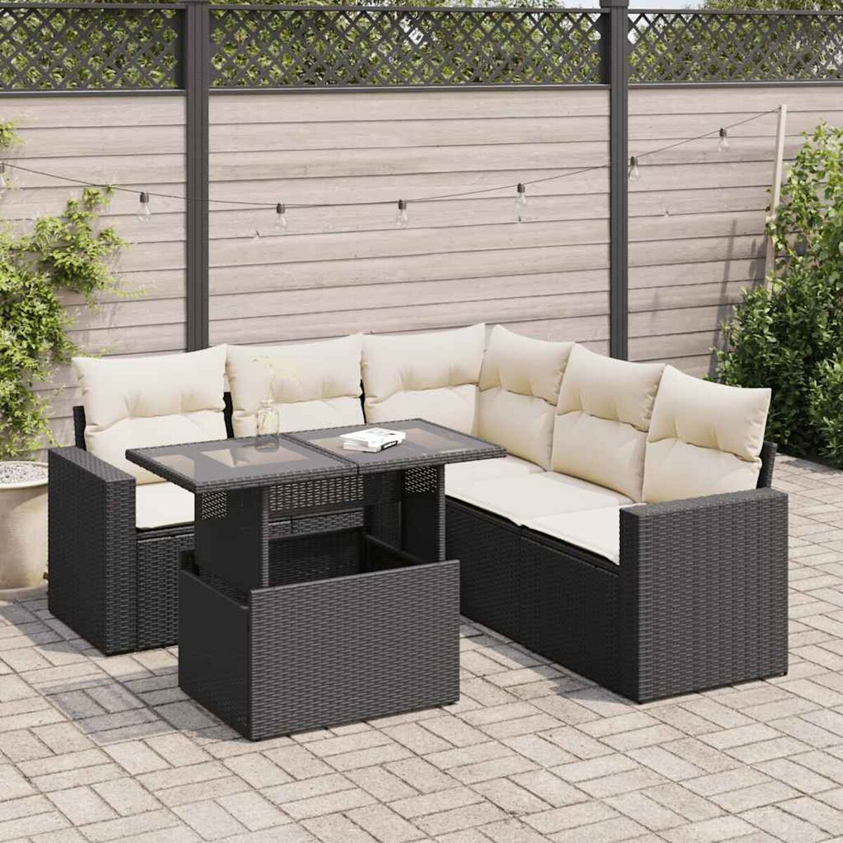 Set divano ad L in rattan nero con tavolo sollevabile, su un patio in mattoni.