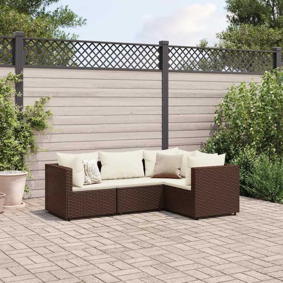 Un set di divani in vimini da esterno marrone, con cuscini beige, in un ambiente patio.