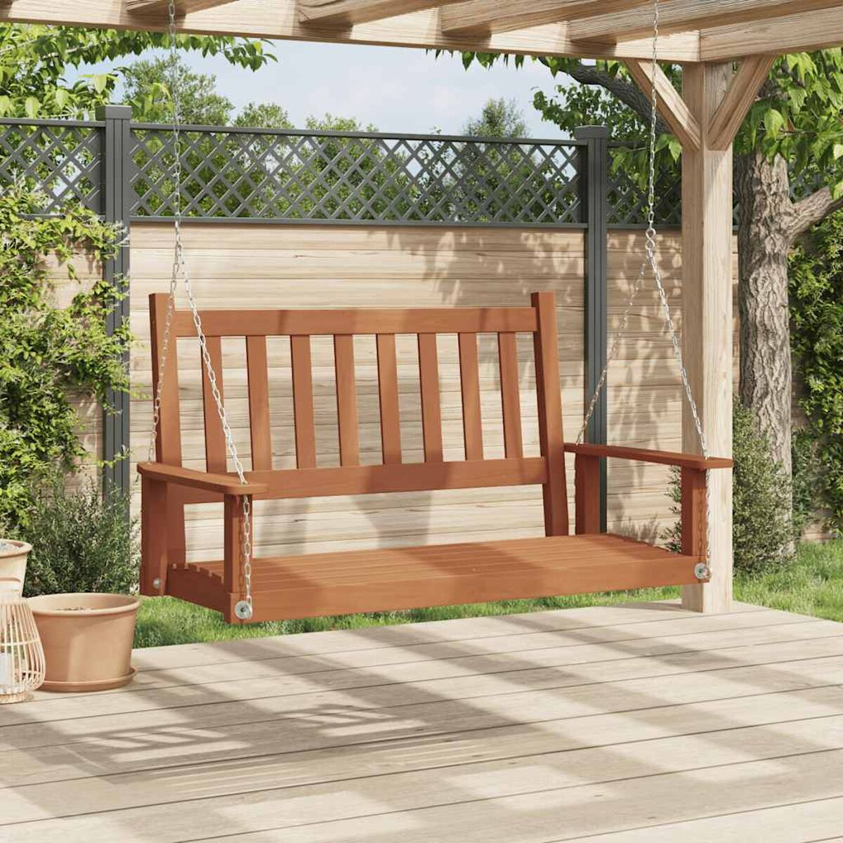 Holzschaukelbank, die an einer Holzpergola auf einer Holzterrasse hängt.