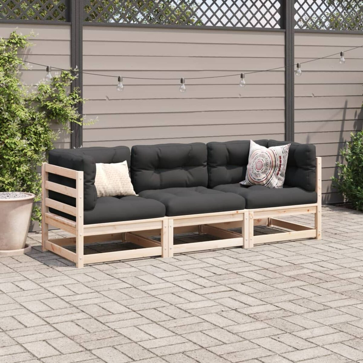 Ein hölzernes Outdoor-Sofa mit schwarzen Kissen und weißen Kissen auf einer Terrasse.