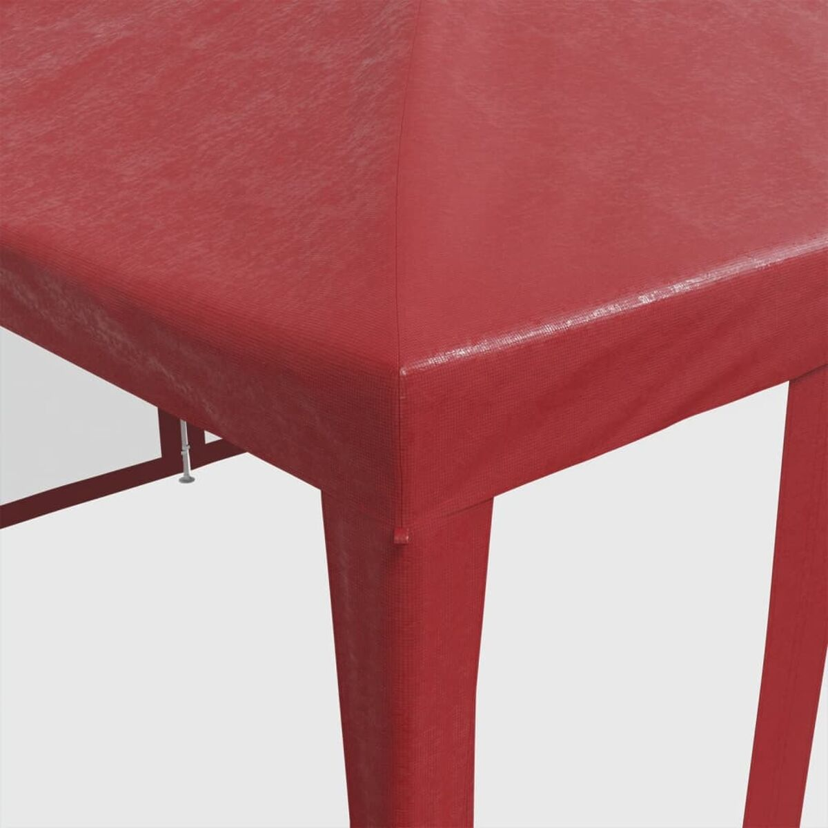 Primo piano della parte superiore di una tenda rossa. La parte superiore è realizzata in materiale strutturato e ha un angolo appuntito.
