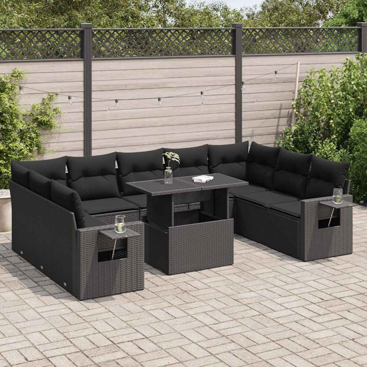 Set divani in vimini nero con tavolino, cuscini e un patio in mattoni.