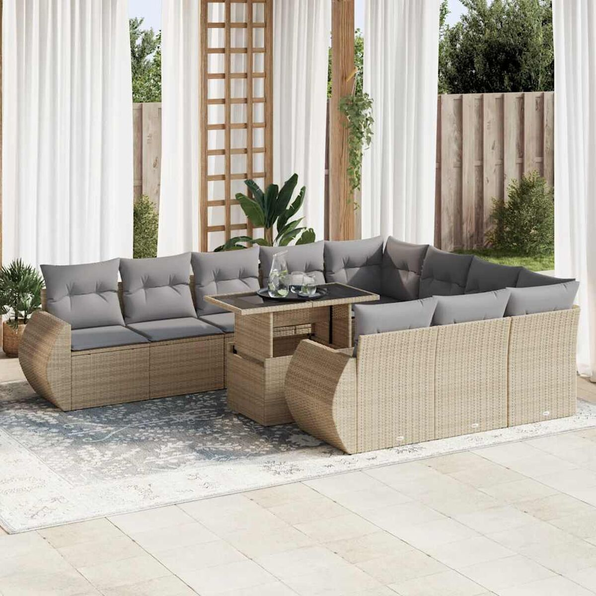 Beiges Outdoor-Ecksofa aus Rattan mit grauen Kissen und einem Tisch mit Glasplatte auf Terrasse.