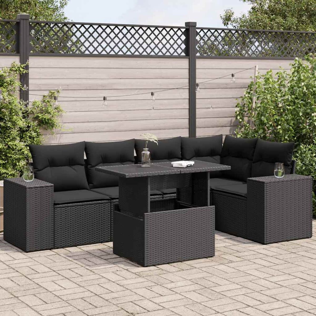 Set di mobili da esterno in vimini nero. Include divano, tavolo e tavolini con cuscini neri.