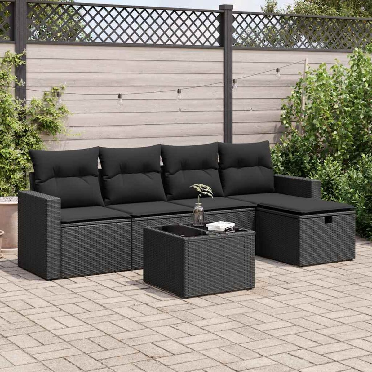 Outdoor-Rattansofa-Set mit schwarzen Kissen und passendem Tisch, Terrasseneinstellung.