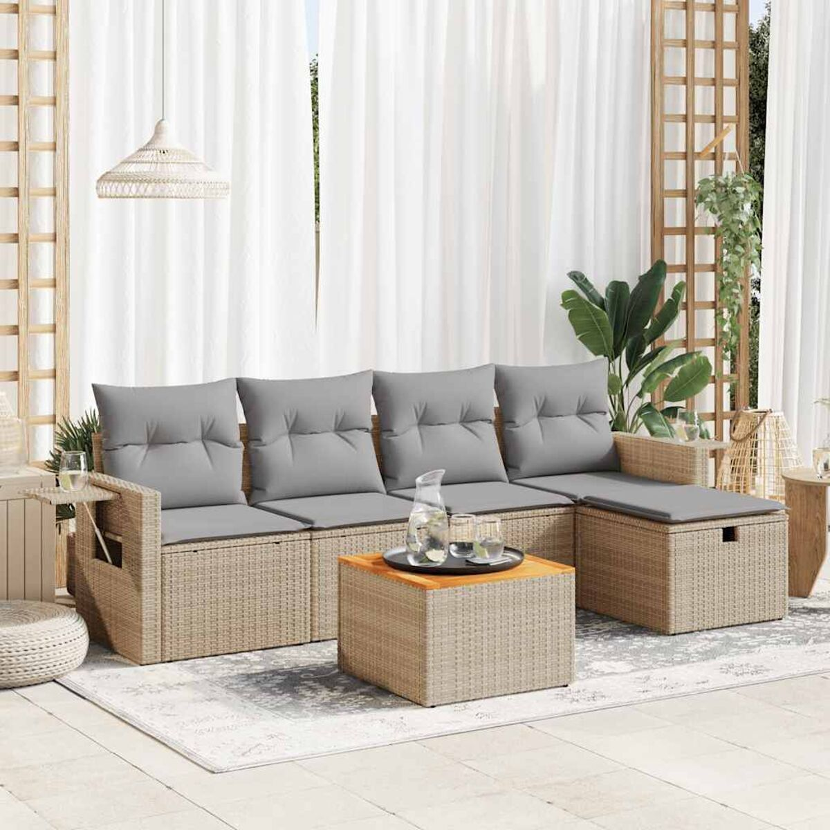Set divano in rattan da esterno con cuscini grigi e tavolino.