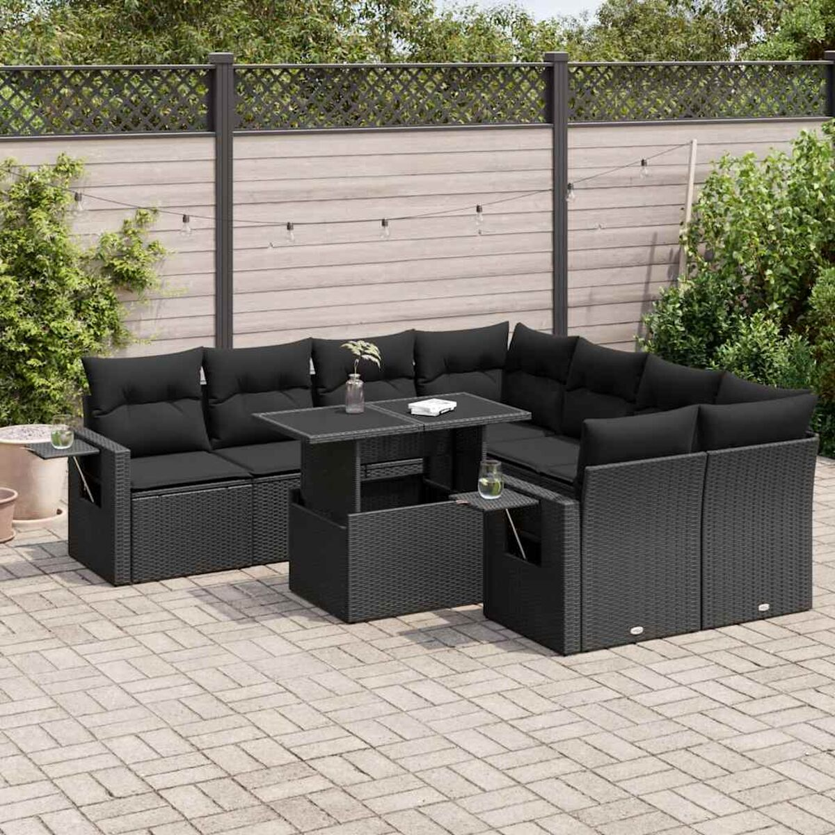 Outdoor-Ecksofa mit schwarzem Korbgeflecht, schwarzen Kissen und einem Tisch. Graue Terrasse.