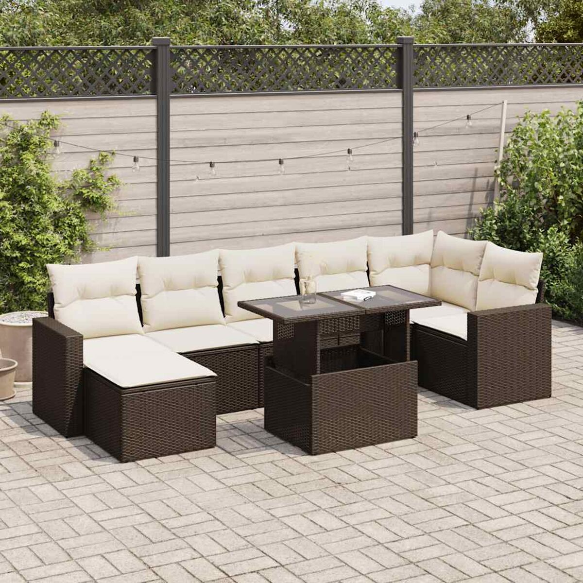 Juego de exterior de mimbre marrón oscuro. Incluye sofá, mesa y otomana. Ambiente de patio. Tono neutro.