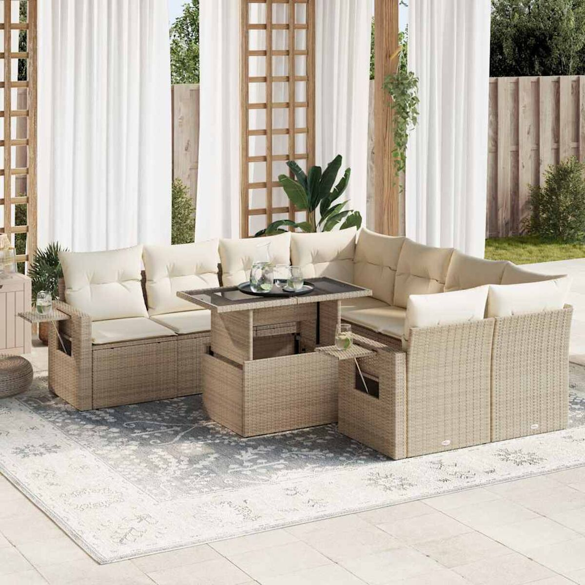 Set di sedute da esterno con cuscini color crema, un tavolo sollevabile e sfondo di tenda bianca, creando uno spazio rilassante.
