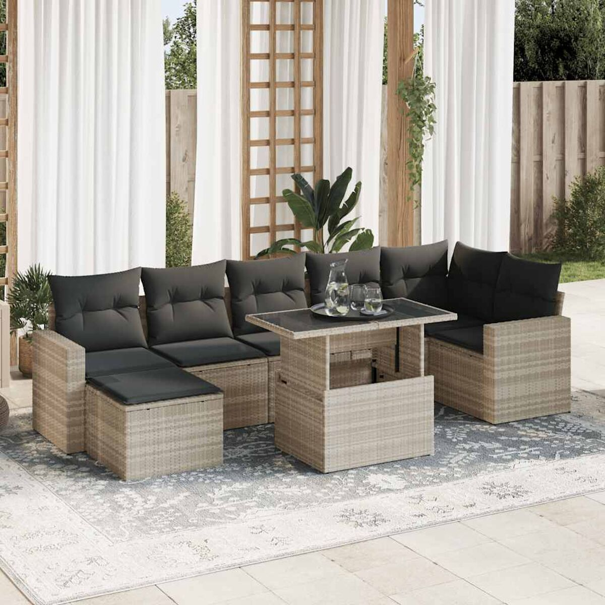 Geflochtenes Outdoor-Ecksofa mit schwarzen Kissen, grauem Teppich und einem Hebetisch mit Gläsern.