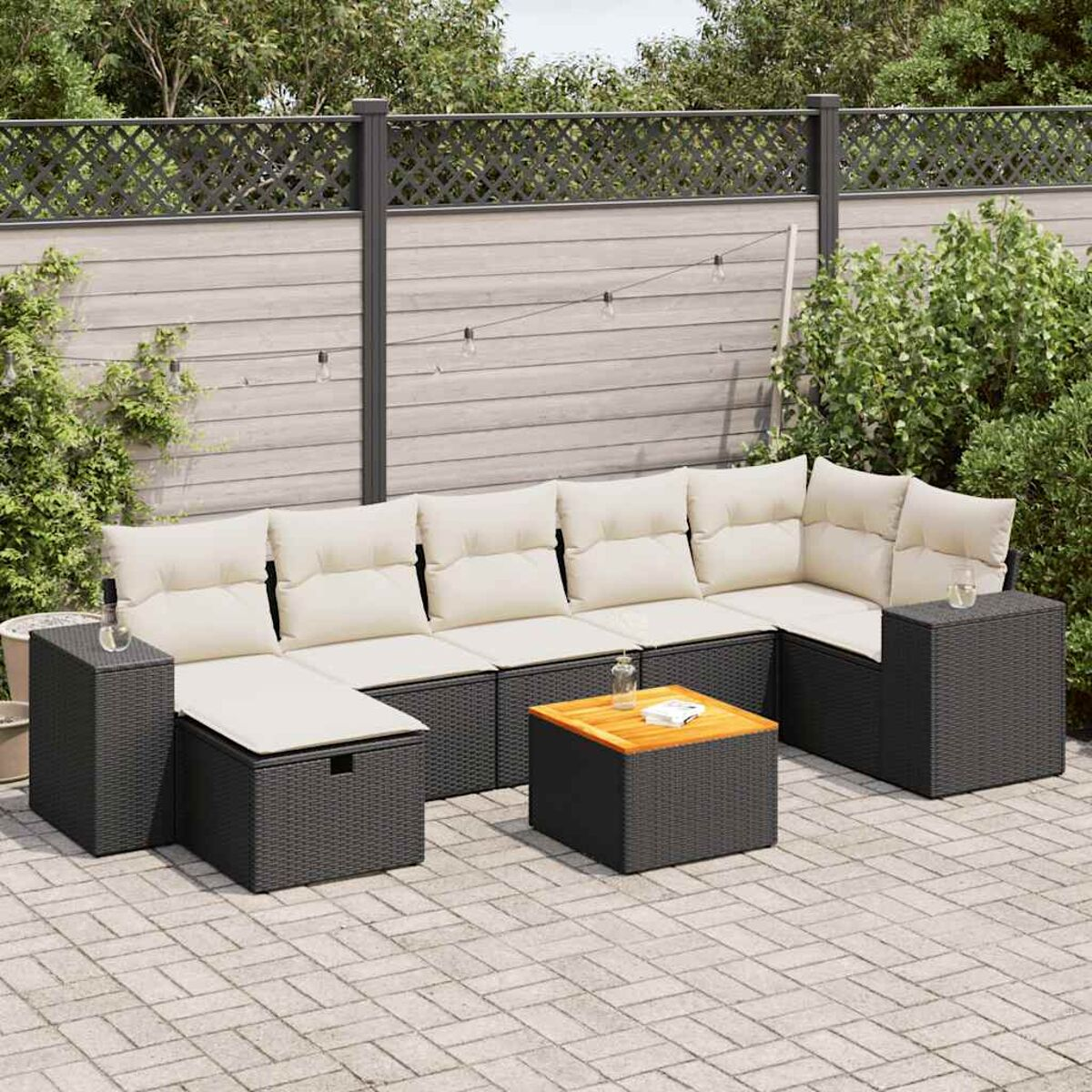 Sofá seccional negro para exteriores con cojines crema, dispuesto en un patio. Presenta una mesa pequeña.
