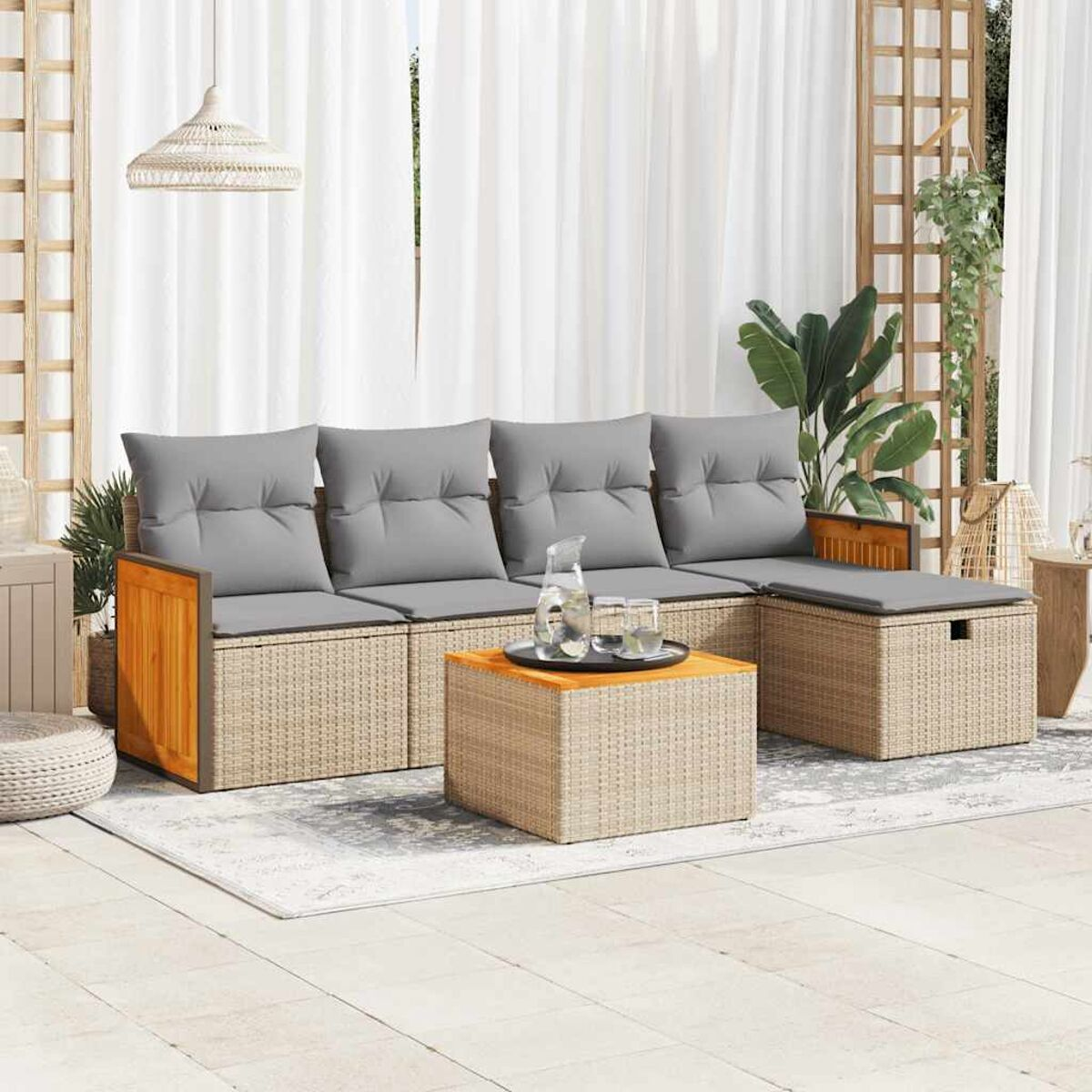 Set divano in rattan beige con cuscini grigi e dettagli in legno. Scena interna.