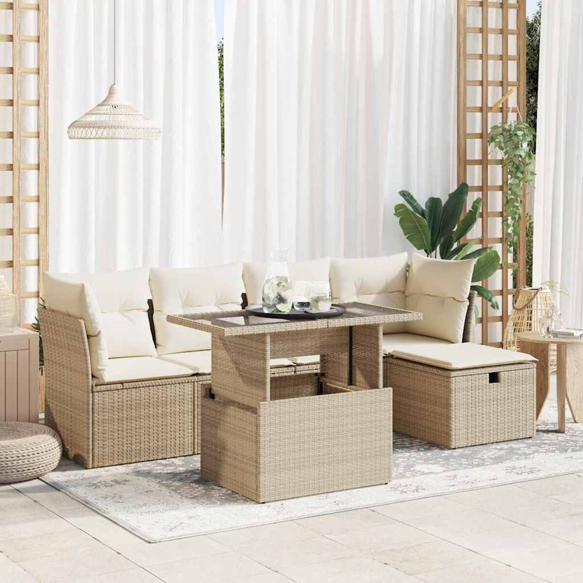 Set divano in rattan beige con tavolo sollevabile, cuscini chiari e decorazioni interne.