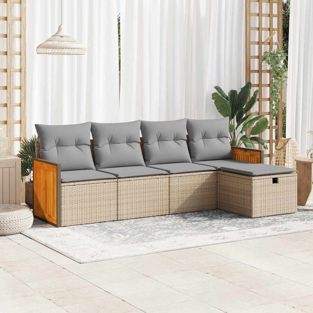 Set divani esterno in stile rattan con cuscini grigi e un tappeto.