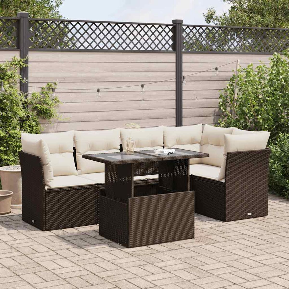 Divano componibile da esterno con tavolo. Rattan marrone scuro con cuscini beige. Patio.