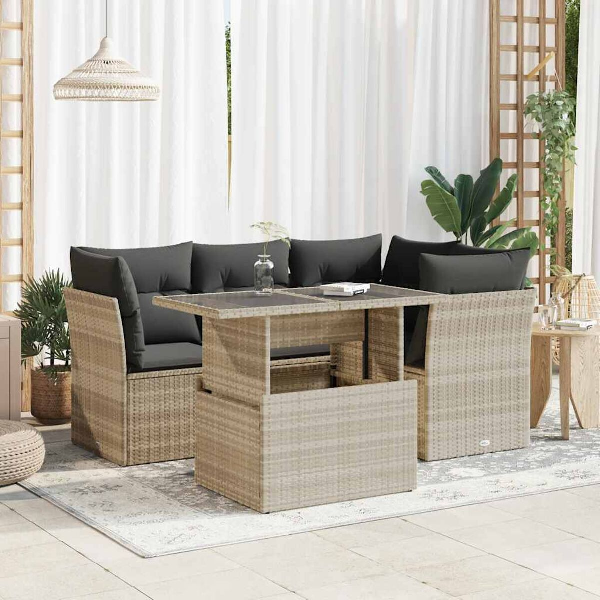 Set da patio in vimini beige con tavolo elevabile. Include un divano e due poltrone su un tappeto.