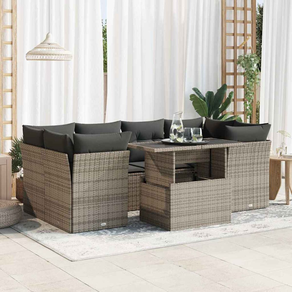 Un set da patio in rattan, tra cui un tavolo sollevabile e un divano componibile.