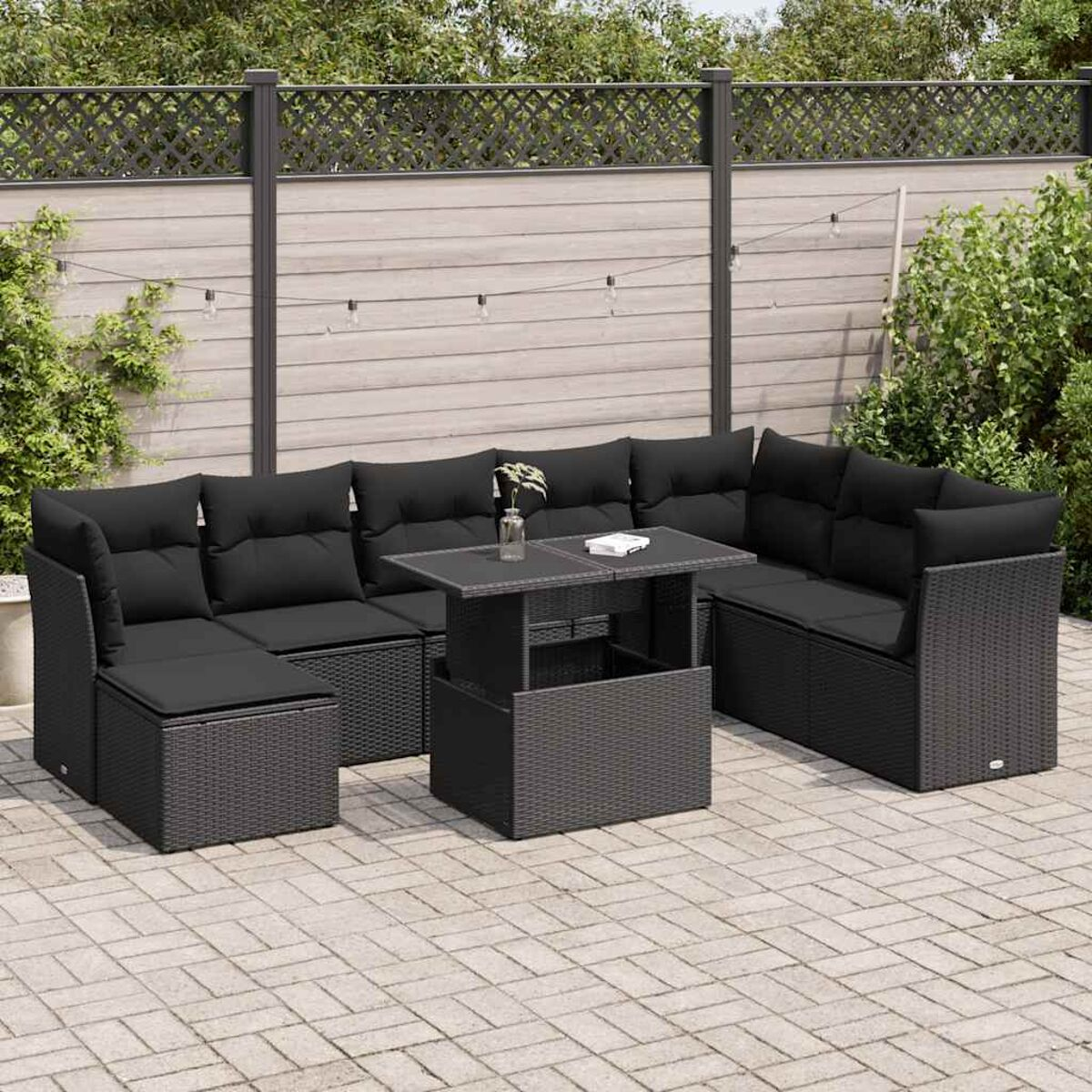 Set di sedute in rattan nero da esterno con tavolo. Ambientazione esterna.