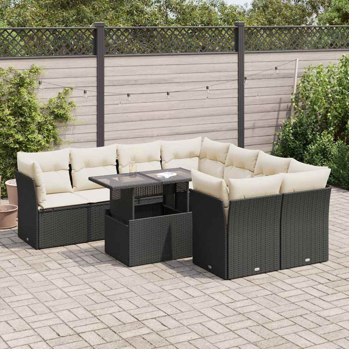 Divano componibile in vimini da esterno con cuscini beige su patio.
