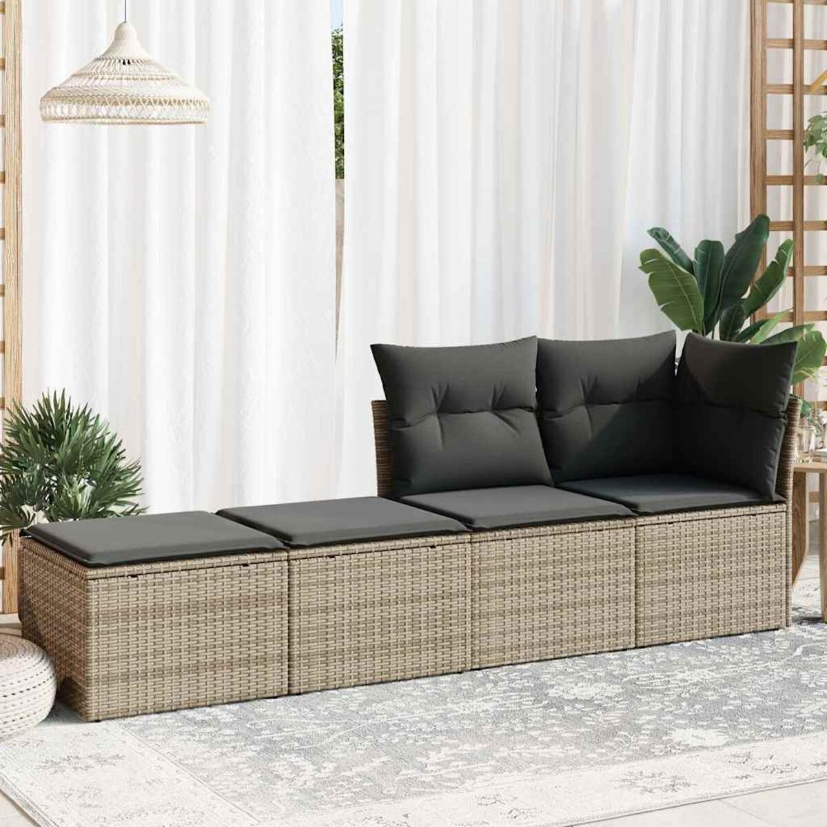 Rattansofa mit grauen Kissen. Das Sofa steht in einem hellen Raum in der Nähe eines Fensters mit weißen Vorhängen.