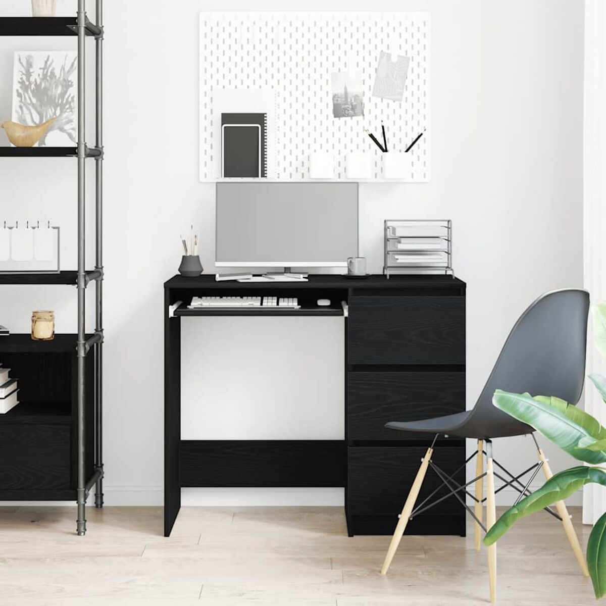 Ein schwarzer Schreibtisch mit Computer, Stuhl und Zubehör vor einer weißen Wand.