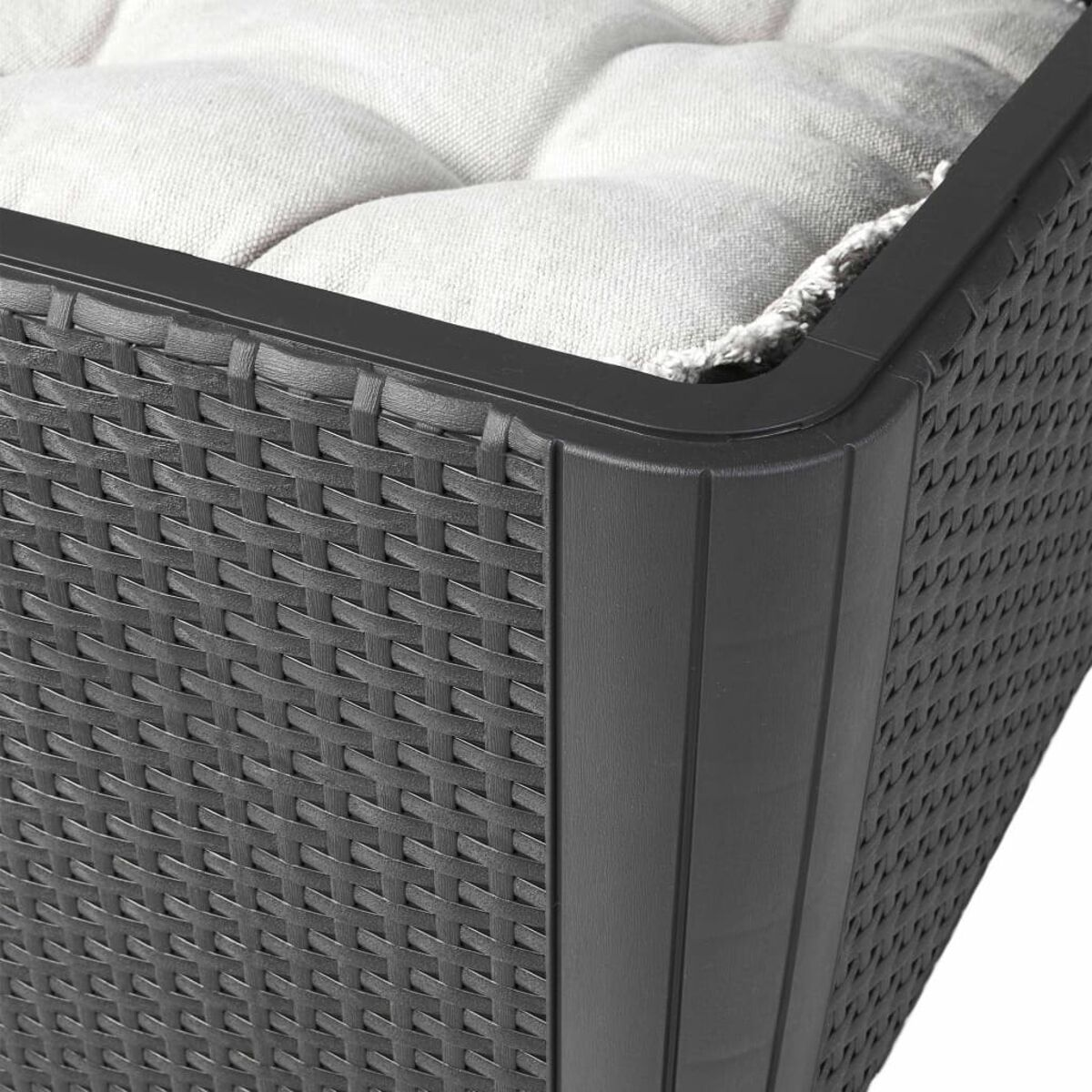 Primo piano di un contenitore in rattan nero con cuscino bianco. La trama è visibile.