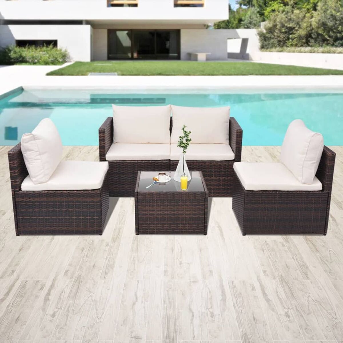 Braunes Outdoor-Möbelset aus Weide mit weißen Kissen und einem Glastisch.